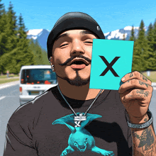 a man with a beard and mustache holds up a card with the letter x on it