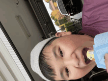 a boy wearing a hat holds a bird in his mouth with a license plate that says ' a ' on it