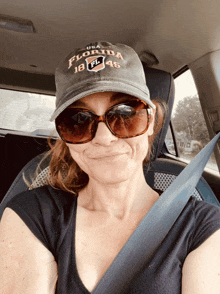 a woman wearing sunglasses and a florida hat