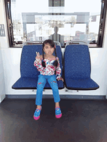 a little girl sitting on a bus with a sign on the window that says ' a & b ' on it