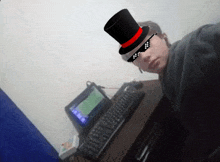 a man wearing a top hat and sunglasses sits at a desk