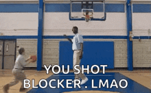 a man is playing basketball in a gym with the words `` you shot blocker . lmao '' written above him .