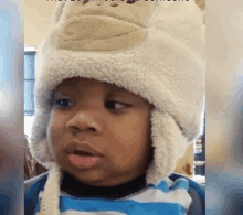 a young boy wearing a monkey hat looks at the camera