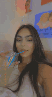 a woman is drinking from a bottle with a blue straw and a date of 01/12/13