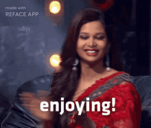 a woman in a red saree is smiling with the words enjoying behind her