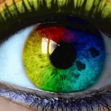 a close up of a person 's eye with a rainbow colored iris