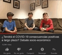 three boys are sitting on a couch in a living room talking about covid-19 .