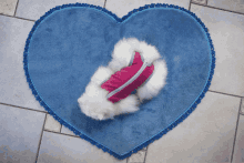 a blue heart shaped rug with a white furry animal on it