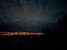 a view of a city at night with the moon visible