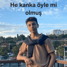 a young man leaning on a railing with the words he kanka öyle mi olmus written above him