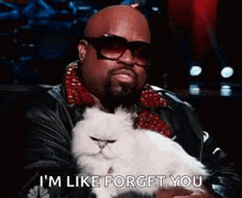 a man is holding a white cat in his arms and says `` i 'm like forget you '' .