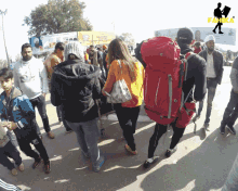 a group of people are walking down a street with a sign in the background that says ' fahika '