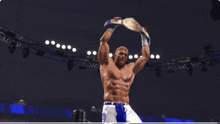 a wrestler is holding a championship belt in the air