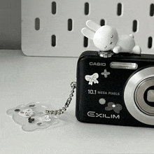 a black casio camera with a white bunny on top of it