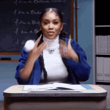 a woman is sitting at a desk in front of a blackboard with the words i am a badass written on it