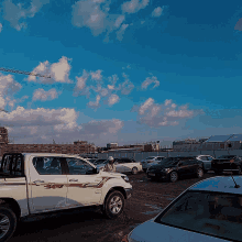 a white truck with the word hilux on the side is parked in a lot