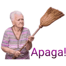 an elderly woman is holding a broom with the word apaga on it .