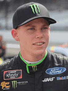 a man wearing a ford shirt and a monster hat