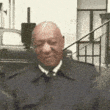 a man wearing a suit and tie is standing in front of a building .