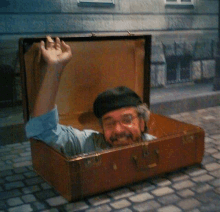 a man in a suitcase is waving his hand