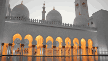 a white mosque with arches and columns and a large dome