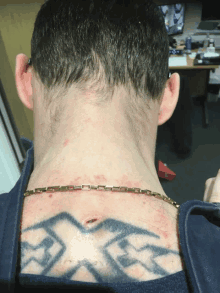 a man has a tattoo on his back that says ' x '