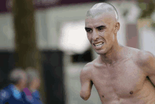 a shirtless man with a shaved head is running