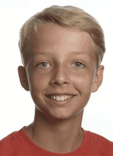 a young boy wearing a red shirt is smiling