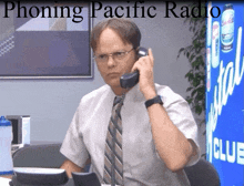 a man is talking on a phone in front of a sign that says ' phoning pacific radio '