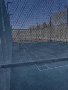 a tennis court is behind a mesh fence