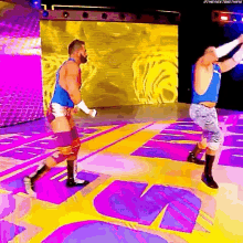 two wrestlers are standing on a stage in a wrestling ring .