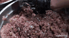 a close up of a person mixing meat in a bowl with the words made in animatica written on the bottom