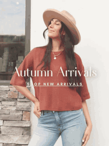 a woman wearing a hat stands in front of a sign that says " autumn arrivals shop new arrivals "