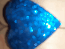 a blue heart shaped object is surrounded by blue sequins