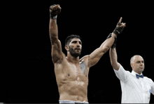 a boxer with his arms in the air is being congratulated by his referee