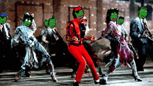 a group of people with green faces are dancing with a man in red pants