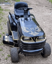 a black lawn mower with a gold eagle on it