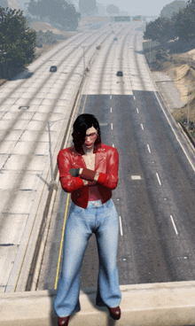 a woman in a red jacket and blue jeans is standing on a bridge over a highway