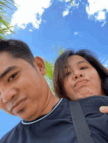 a man and a woman are posing for a picture with the woman making a funny face