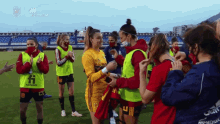 a group of female soccer players are standing on a field wearing face masks and jerseys with the letters h on them