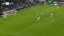 two soccer players are giving each other a high five in front of a scoreboard that says university of birmingham london