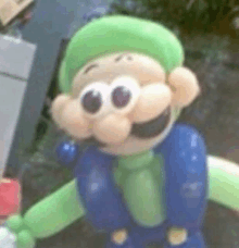 a close up of a balloon mario character with a green hat