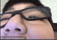 a close up of a person wearing glasses with kat gamer xxxjaberxxx written on the bottom