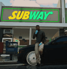 a man is standing in front of a subway restaurant