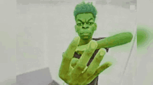 a man with green hair is holding a green object in his hand and giving the middle finger .