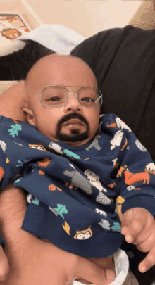 a baby wearing glasses and a beard is being held