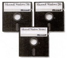 three floppy disks for microsoft windows are stacked on top of each other on a white background .