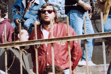 a man wearing sunglasses and a red jacket with the word salem on the back