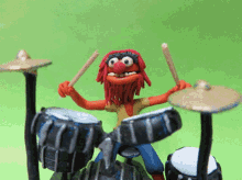 a cartoon character is playing drums with a green background