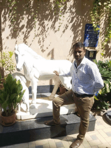 a man stands in front of a statue of a horse and a sign that says ' bharat ratna '